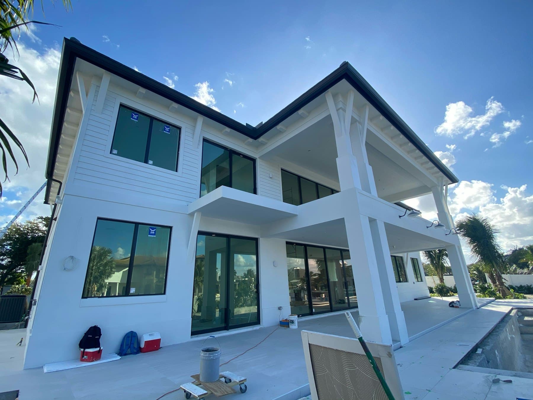 Newly installed black-framed windows on a white residential home