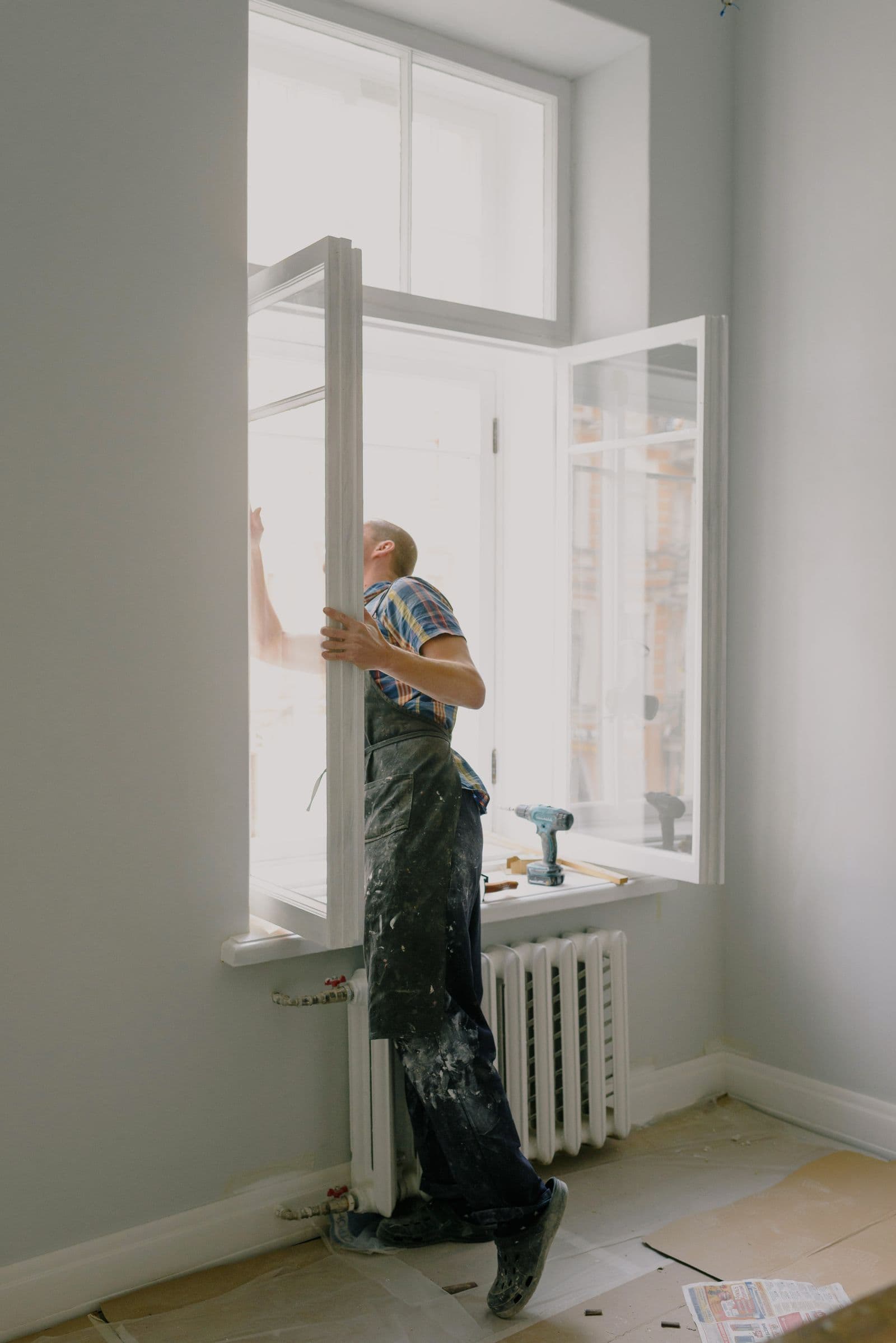 Installer setting a new window sash into a residential window opening